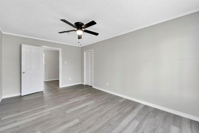 unfurnished room featuring a textured ceiling, light hardwood / wood-style flooring, ceiling fan, and crown molding