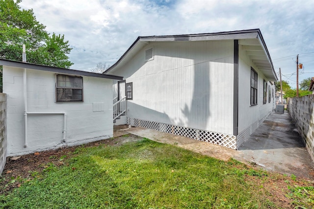 view of side of home with a yard