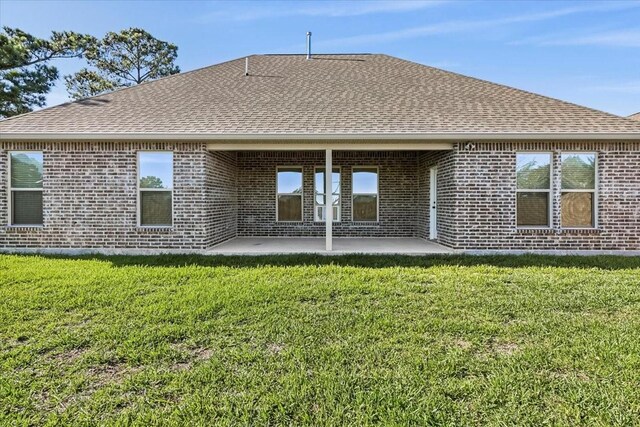 rear view of house featuring a patio and a lawn