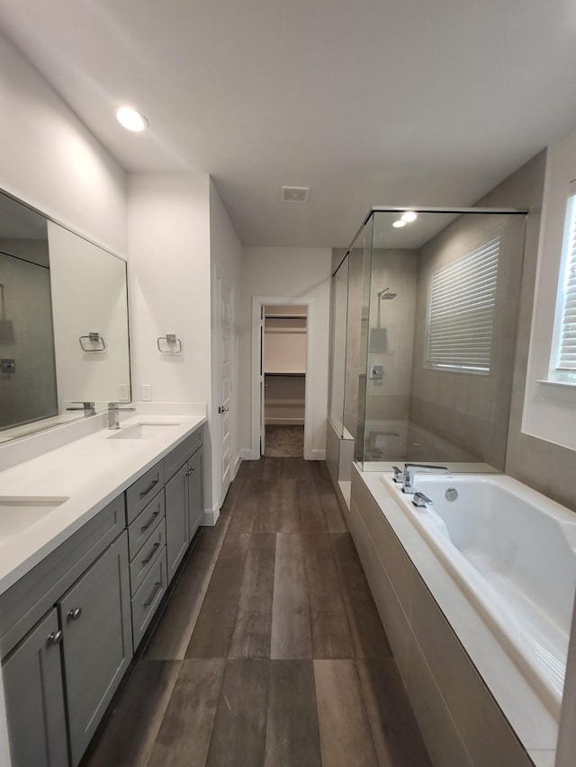 bathroom with vanity, hardwood / wood-style flooring, and independent shower and bath