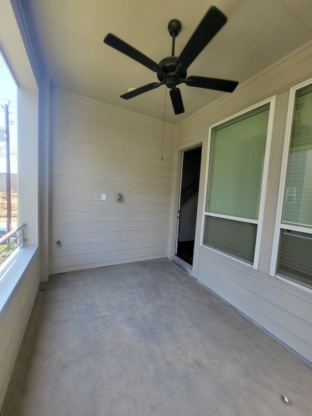 unfurnished sunroom with ceiling fan