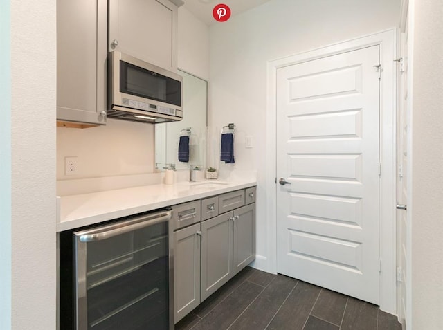 kitchen with gray cabinetry, dark wood-type flooring, and wine cooler