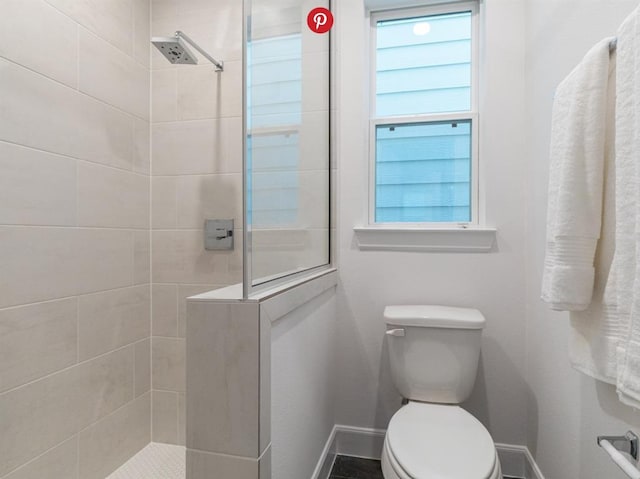 bathroom with toilet and tiled shower