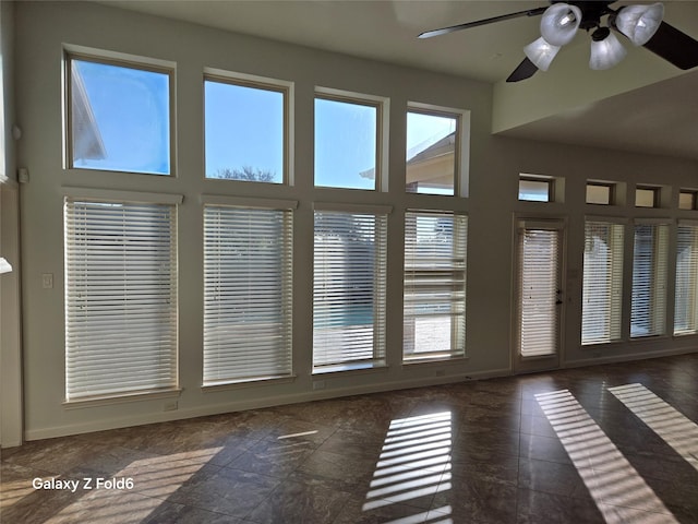 interior space with ceiling fan and a high ceiling