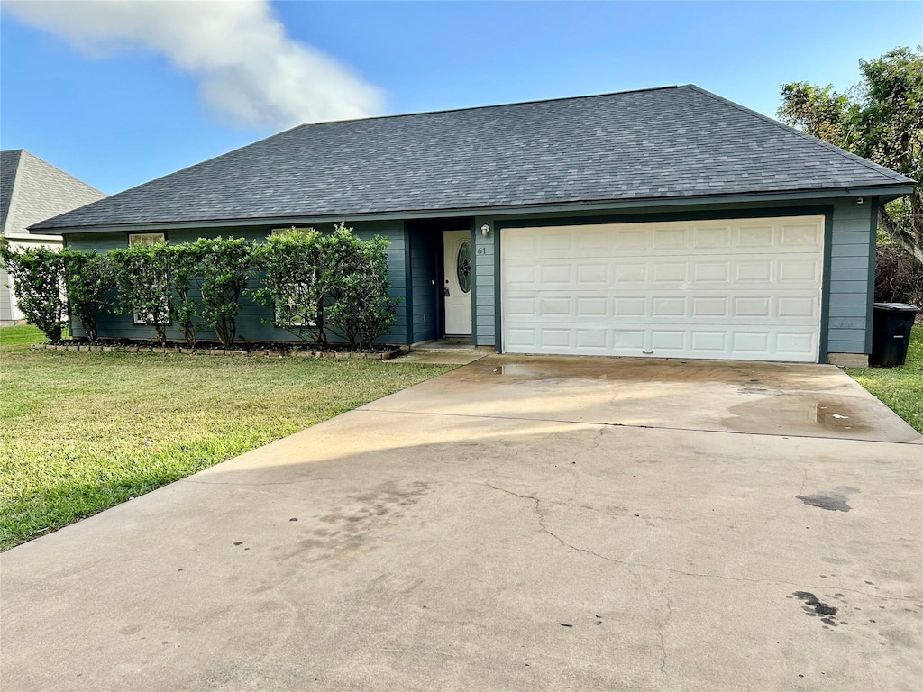 single story home featuring a garage and a front lawn