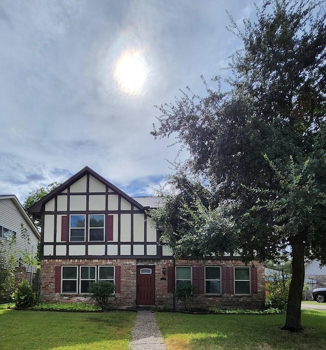 tudor-style house featuring a front yard