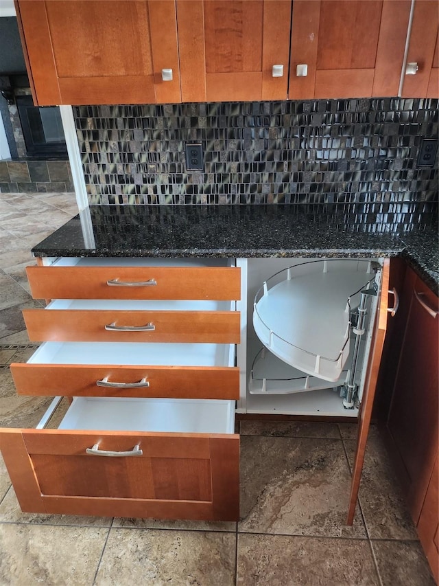 room details featuring dark stone countertops and backsplash