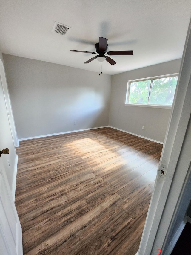 unfurnished room with dark hardwood / wood-style floors and ceiling fan