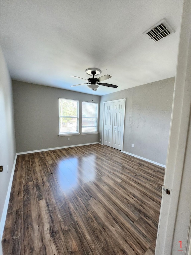 empty room featuring ceiling fan and dark hardwood / wood-style flooring