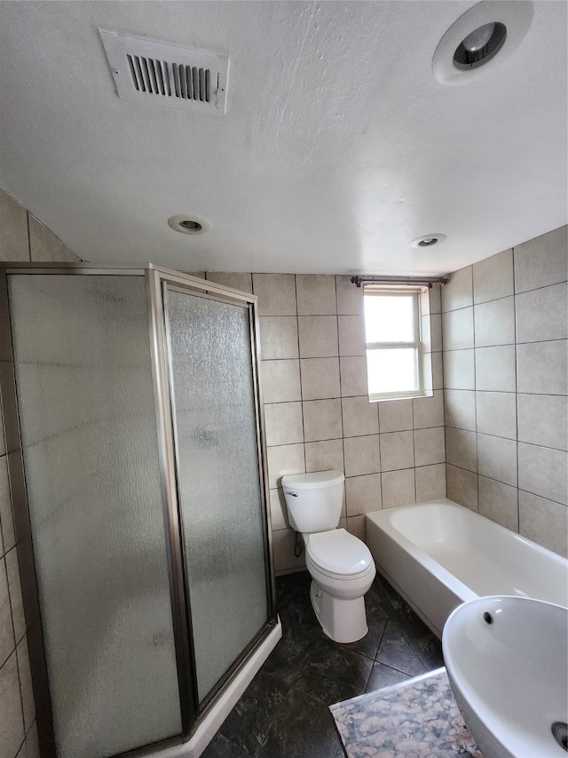 bathroom with tile patterned flooring, toilet, tile walls, and independent shower and bath