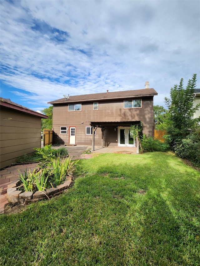 rear view of house with a lawn and a patio area