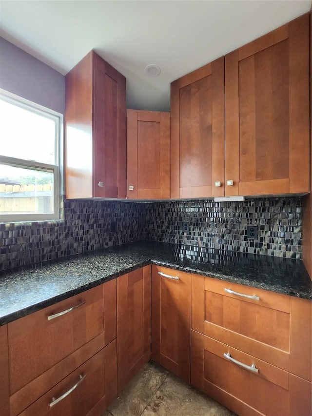 kitchen featuring dark stone counters and tasteful backsplash