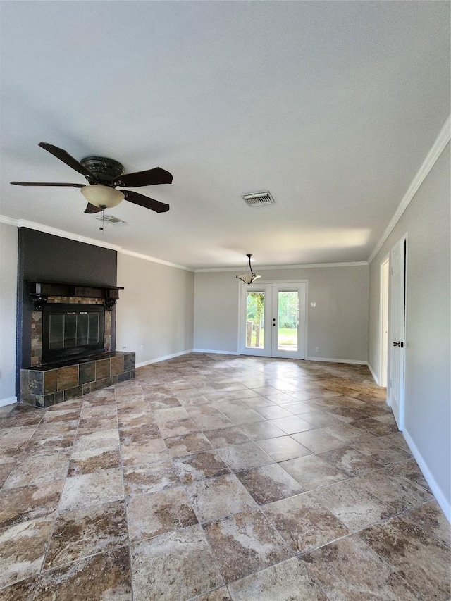 unfurnished living room featuring ceiling fan, french doors, crown molding, and a tiled fireplace