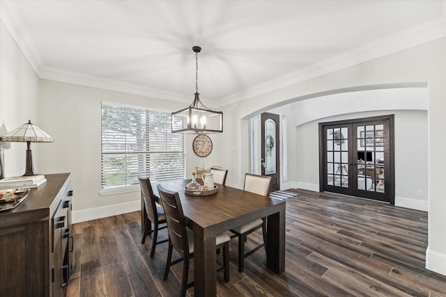 dining room featuring a chandelier, french doors, ornamental molding, and dark wood-type flooring