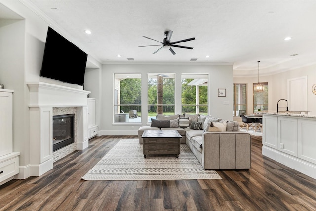 living room with ceiling fan, dark hardwood / wood-style flooring, and ornamental molding