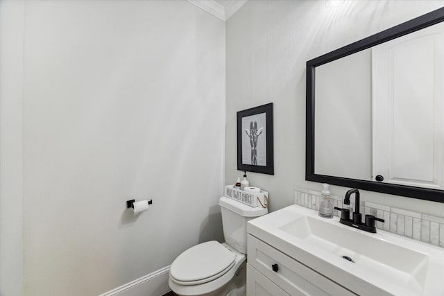 bathroom featuring vanity, toilet, and ornamental molding