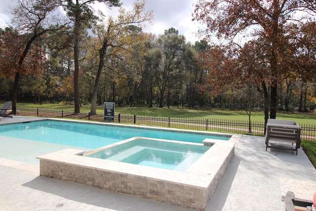 view of swimming pool featuring a lawn and an in ground hot tub