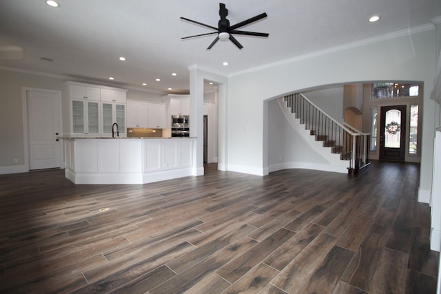 unfurnished living room with dark hardwood / wood-style floors, ceiling fan, ornamental molding, and sink