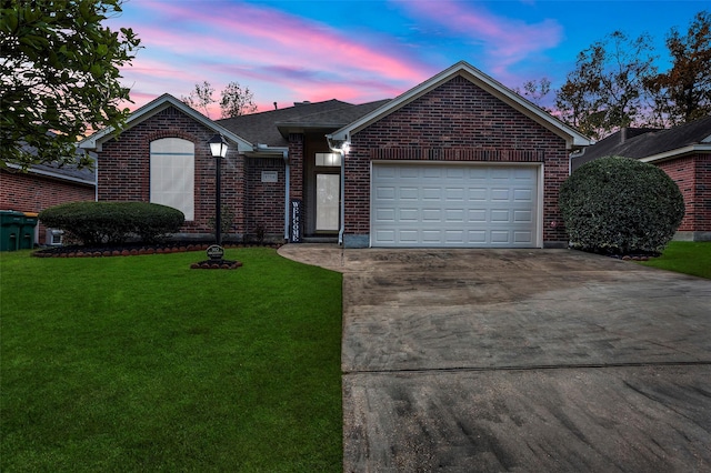 ranch-style house featuring a garage and a yard