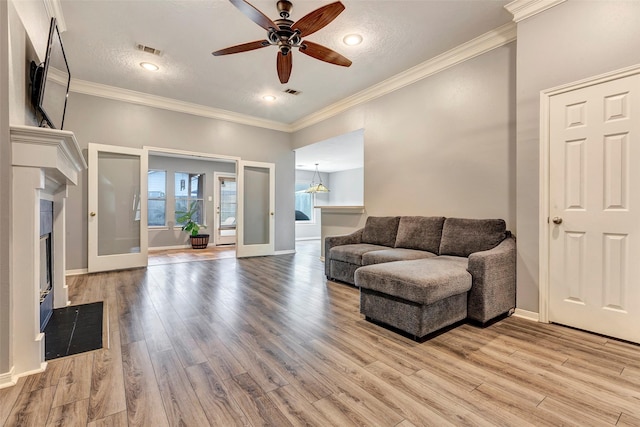 living room with french doors, light hardwood / wood-style floors, and crown molding