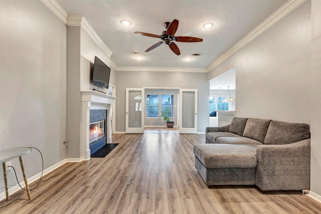 living room featuring ceiling fan, french doors, wood-type flooring, and a textured ceiling