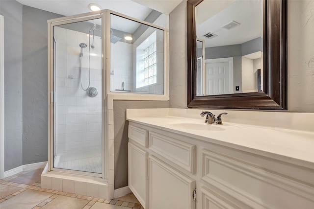 bathroom with tile patterned flooring, vanity, and an enclosed shower