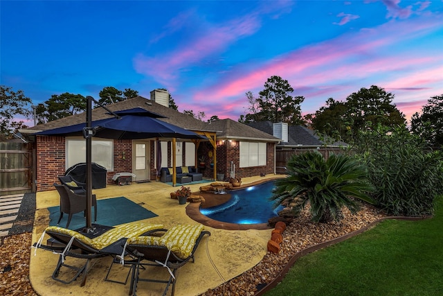 back house at dusk featuring outdoor lounge area and a patio