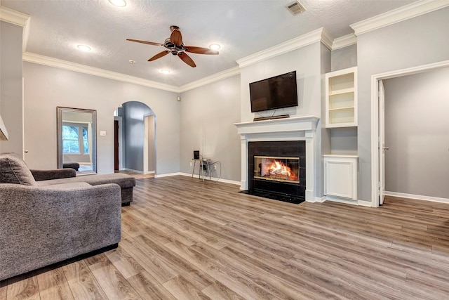 living room with a fireplace, ceiling fan, hardwood / wood-style floors, and a textured ceiling