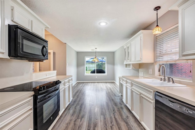 kitchen featuring black appliances, white cabinets, sink, hanging light fixtures, and dark hardwood / wood-style flooring