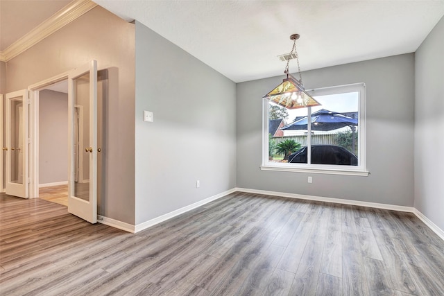 unfurnished room with hardwood / wood-style floors, crown molding, and french doors