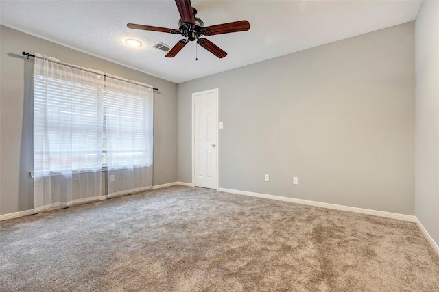 spare room featuring carpet, ceiling fan, and a textured ceiling