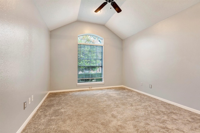 carpeted empty room with a textured ceiling, ceiling fan, and lofted ceiling