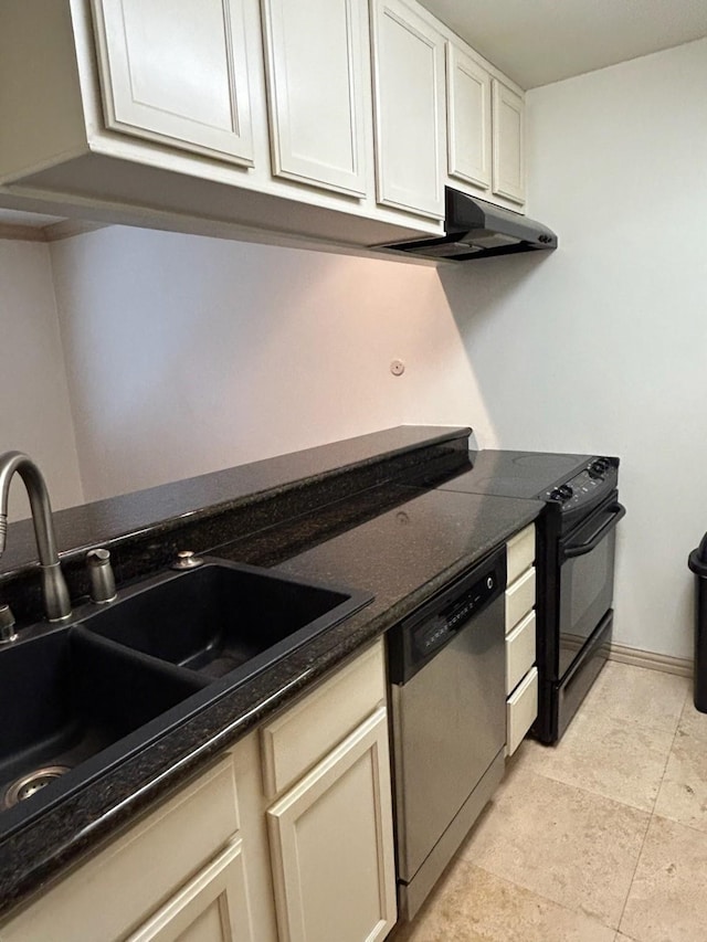 kitchen with stainless steel dishwasher, dark stone countertops, and sink