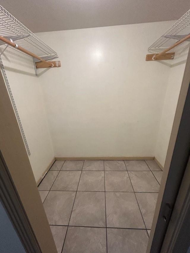 spacious closet with light tile patterned floors