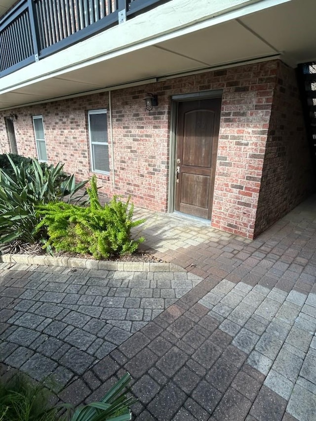 view of exterior entry featuring a balcony