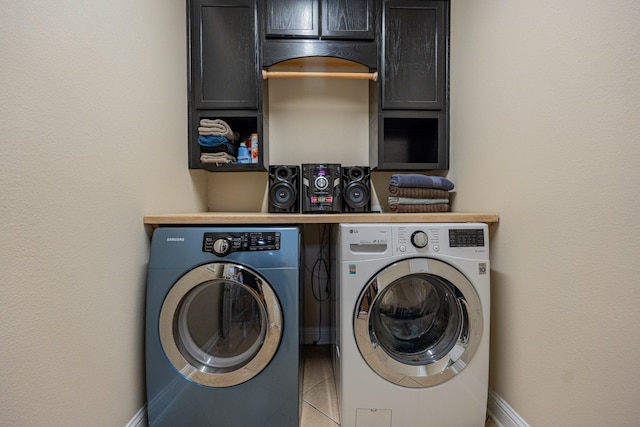 laundry room with light tile patterned flooring, cabinets, and independent washer and dryer