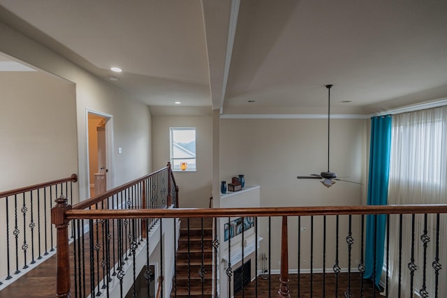 stairs with crown molding, ceiling fan, and wood-type flooring