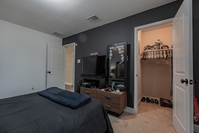 bedroom featuring light carpet and a textured ceiling