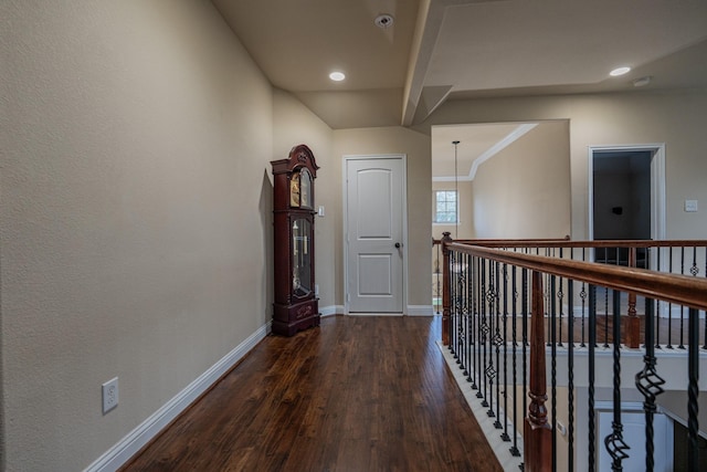 corridor with ornamental molding and dark wood-type flooring