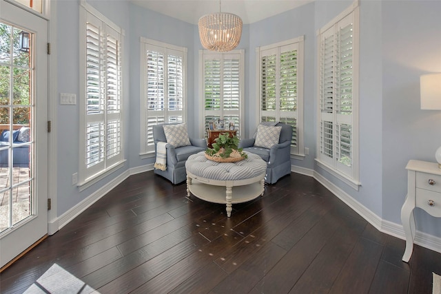 sitting room with an inviting chandelier, a wealth of natural light, and dark wood-type flooring