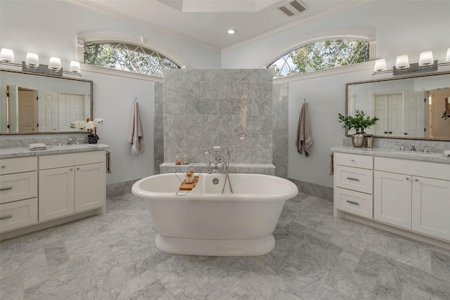 bathroom featuring vanity, a tub to relax in, and crown molding