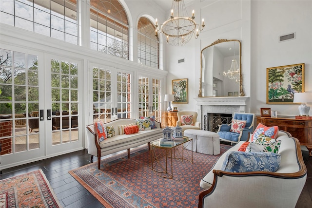 living room with a fireplace, french doors, and a towering ceiling