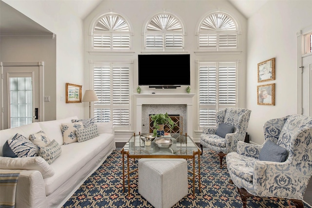 living room featuring high vaulted ceiling and ornamental molding