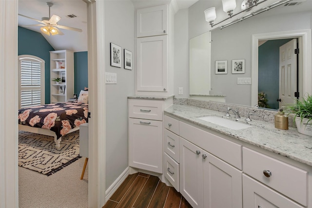 bathroom with hardwood / wood-style floors, ceiling fan, vanity, and vaulted ceiling