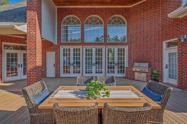 wooden deck with french doors, area for grilling, and a patio area