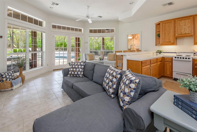 living room featuring ceiling fan, a healthy amount of sunlight, light tile patterned floors, and french doors