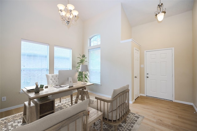 entrance foyer with high vaulted ceiling, light hardwood / wood-style floors, and a notable chandelier