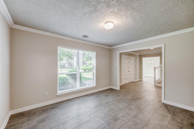 empty room featuring a chandelier, a textured ceiling, and ornamental molding