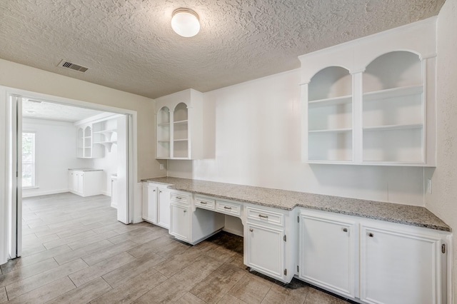 unfurnished office with light hardwood / wood-style floors and a textured ceiling