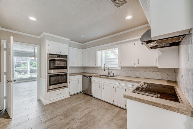 kitchen featuring appliances with stainless steel finishes, crown molding, sink, light hardwood / wood-style flooring, and white cabinetry